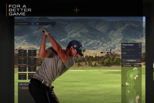 Man Practicing Golf Swing in Indoor Simulator